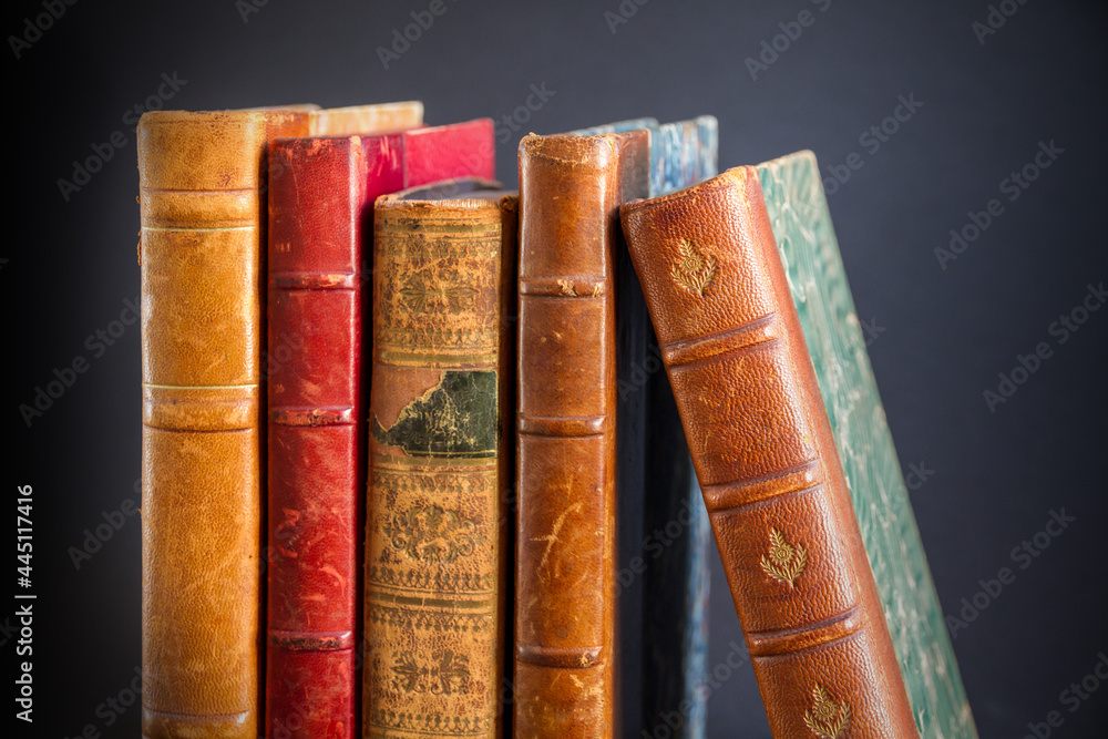 Row of old books on dark background Row of old books on dark background