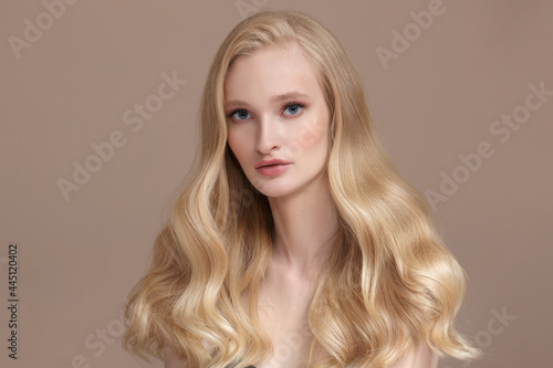 Portrait of a young attractive woman with long wavy blond shiny hair