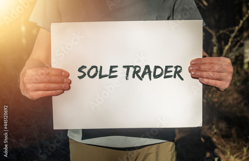 SOLE TRADER TEXT ON paper IN HANDs photo