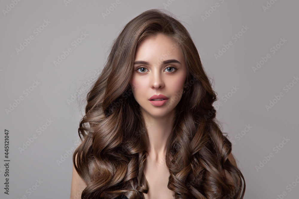 Naklejka premium portrait of a beautiful woman with large curls and dark brown hair