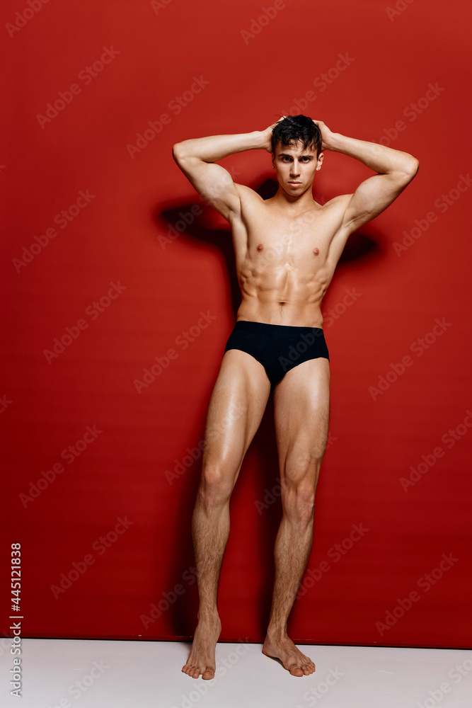 handsome man with a naked torso and black panties and hands behind his head handsome man with a naked torso and black panties and hands behind his head