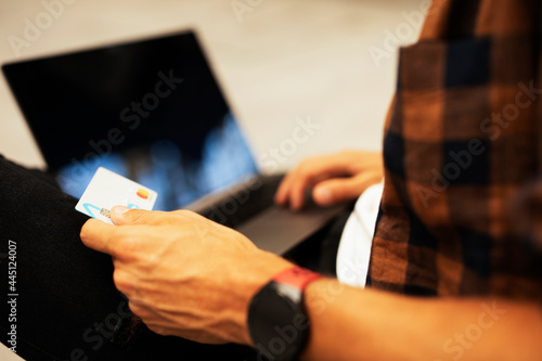 Man shopping online with laptop. Young man buying online with credit card.
