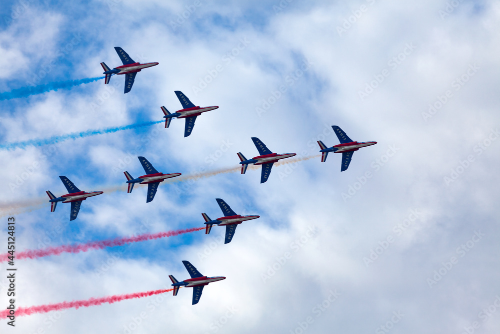 Paris, France - July 14 2021: The French Air Patrol (French: Patrouille de France) performing a demonstration to celebrate the Bastille Day. Paris, France - July 14 2021: The French Air Patrol (French: Patrouille de France) performing a demonstration to celebrate the Bastille Day.