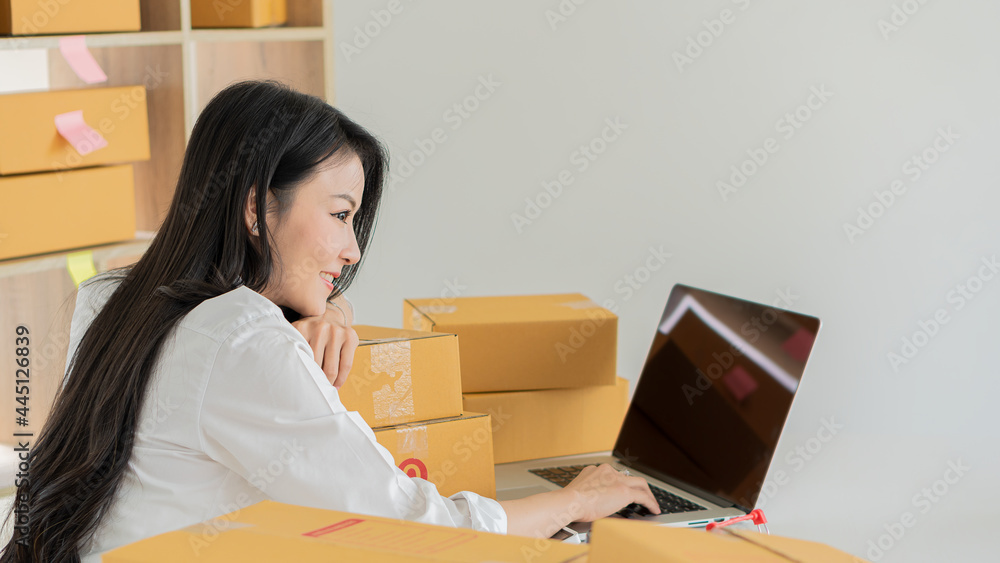 Starting an Asian Entrepreneur Small business, SME independent, young woman working at home with boxes on the floor and laptop online, marketing, packaging, transportation, SME, e-commerce concept Starting an Asian Entrepreneur Small business, SME independent, young woman working at home with boxes on the floor and laptop online, marketing, packaging, transportation, SME, e-commerce concept