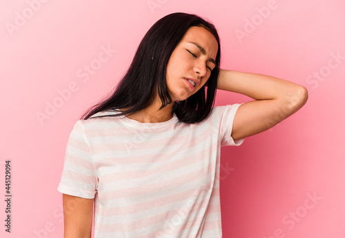 Young Venezuelan woman isolated on pink background tired and very sleepy keeping hand on head.