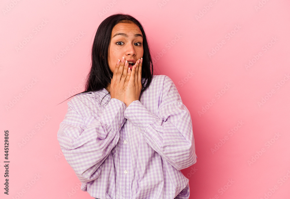 Young Venezuelan woman isolated on pink background shocked, covering mouth with hands, anxious to discover something new. Young Venezuelan woman isolated on pink background shocked, covering mouth with hands, anxious to discover something new.