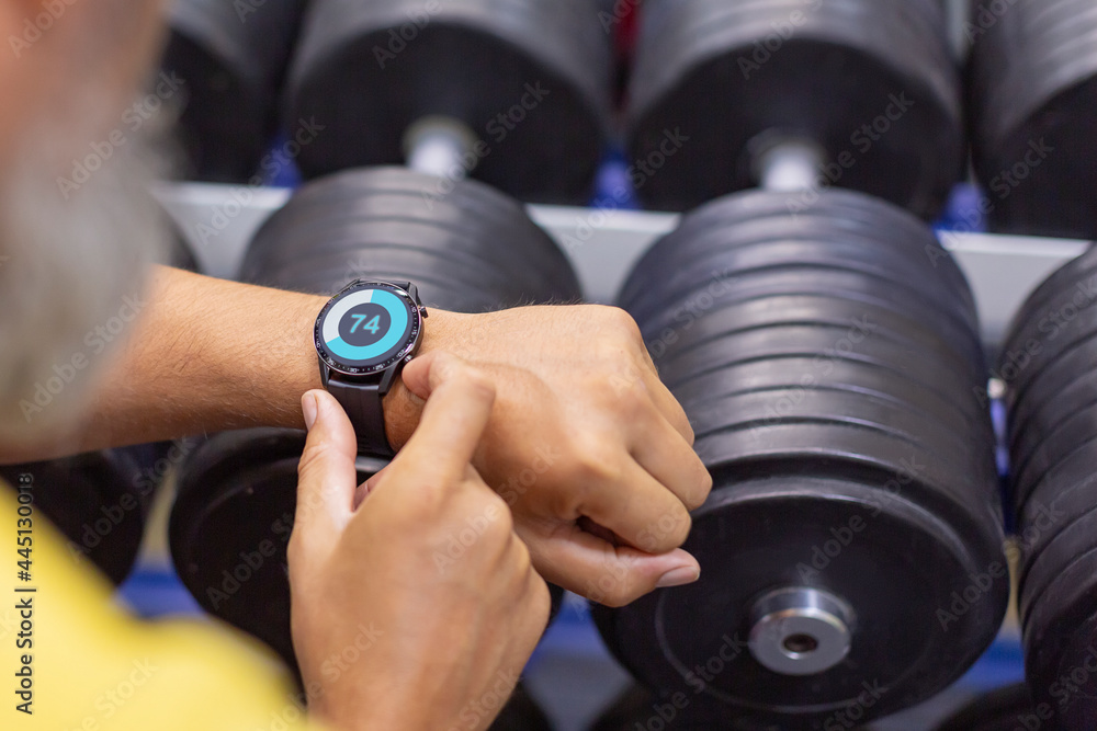 Hands of a man with a smart watch in the gym close-up. Hands of a man with a smart watch in the gym close-up.