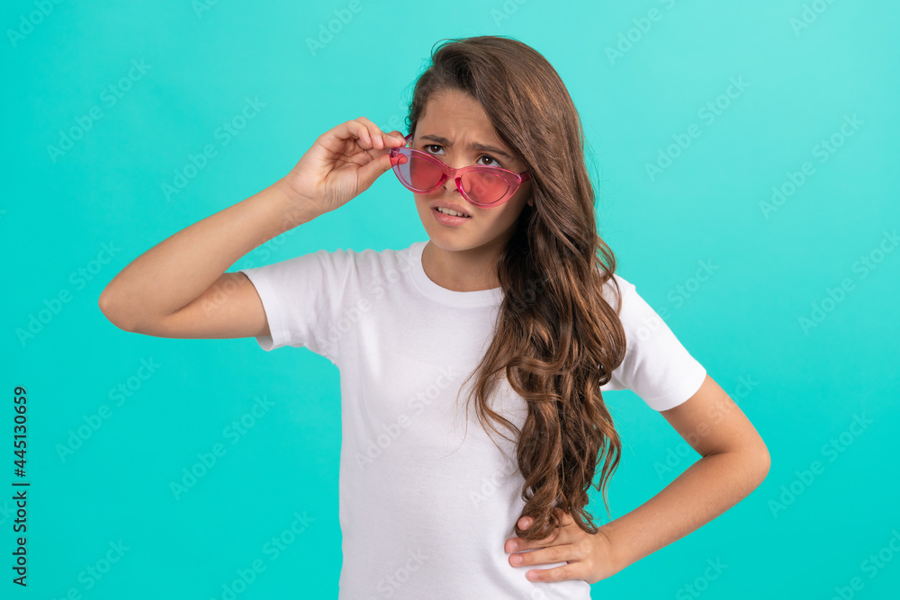 Fototapeta premium unhappy kid long curly hair in sunglasses casual style on blue background, fashion style