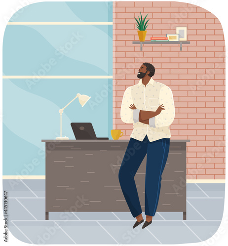 Office worker standing next to table with laptop. Businessman or clerk working at his office workplace. Smiling man enterpreneur resting during break in working day, thinking about something
