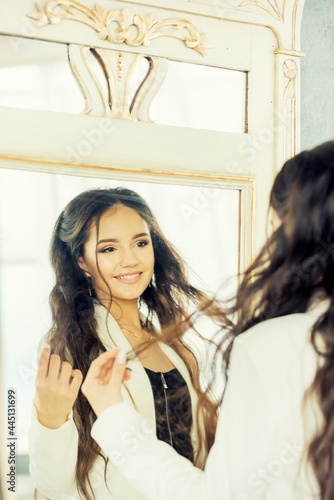Free Download Cute young girl with long hair admires herself in the mirror - GFXLoad