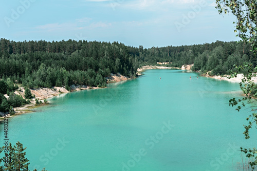 Fototapeta Naklejka Na Ścianę i Meble -  View of the blue turquoise river or lake with coniferous wooded banks, beautiful landscape with bright water