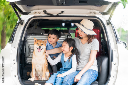Tableau sur toile Happy family with Shiba inu dog in car outdoors