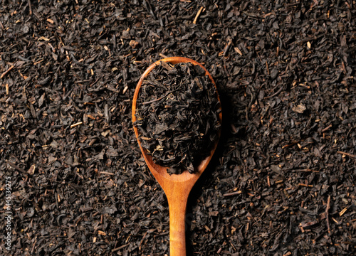 Background with tea leaves and a wooden spoon for the entire screen.