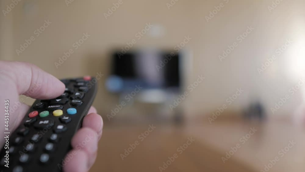 Male hand holding remote the control turn off smart tv. Man hand controls holding remote. Concept online video streaming service.