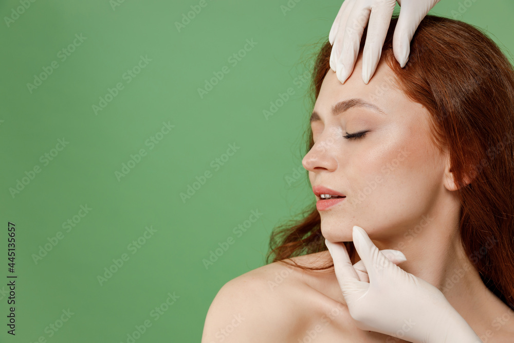 Obraz premium Beautiful side view half naked topless redhead woman 20s nude make up visit doctor hand touching face close eyes isolated on pastel green background Skin care cosmetic consultation procedures concept.