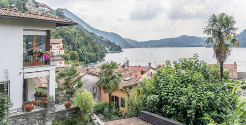 tile roofs near water at village on lake shore, Torno,  Como, Italy