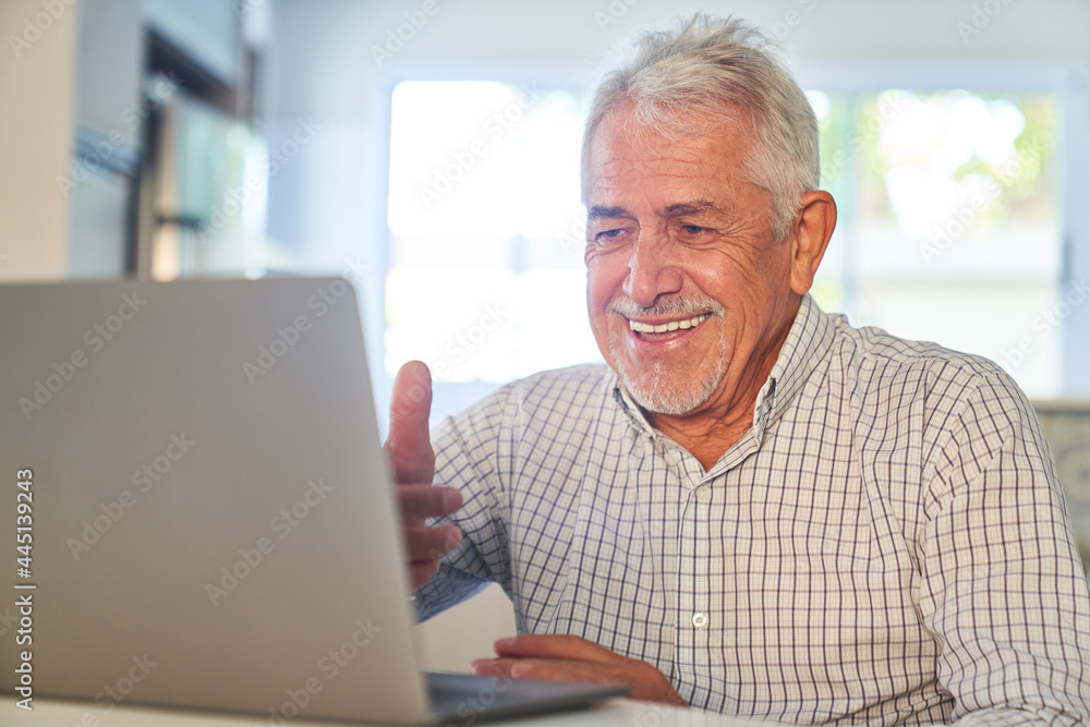 Senior Mann hat Spaß am Zoom Videochat am Computer