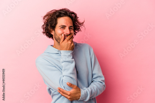 Young caucasian man isolated on pink bakcground laughing happy, carefree, natural emotion.