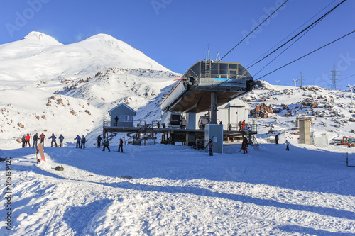 The upper station of the cable car at the ski resort. On the background there is a blue sky and mountain peaks