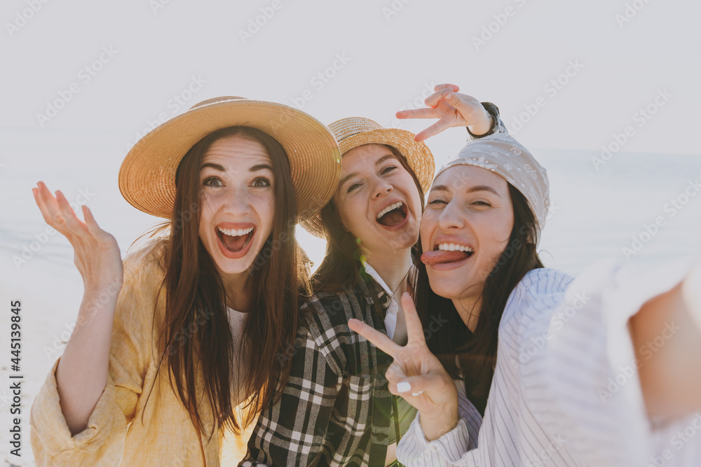 Close up female friend young women 20s in straw hat summer clothes hang out together do selfie shot on mobile cell phone fooling around outdoor on sea beach background People vacation journey concept.