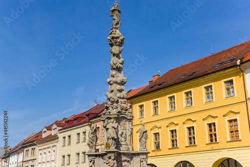 Statues on the column in front of colorful houses in Kutna Hora, Czech Republic