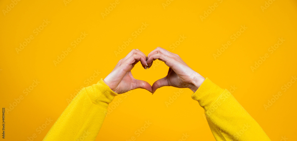 Hands making heart shape isolated on a yellow background - Love and minimal fashion concept	
 - obrazy, fototapety, plakaty 