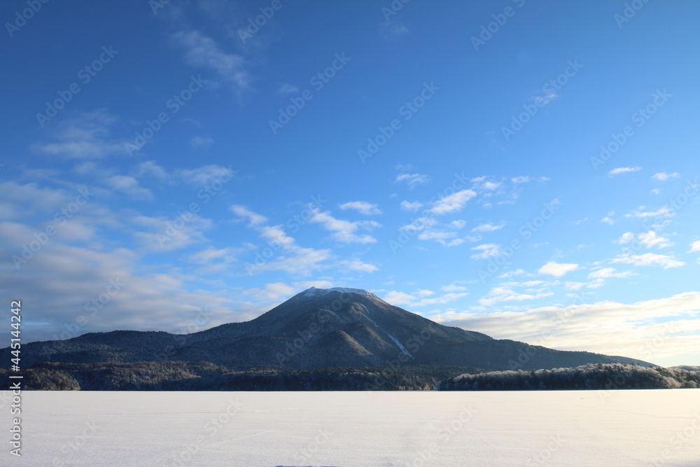 冬の阿寒湖の湖上から雄阿寒岳と白銀の森