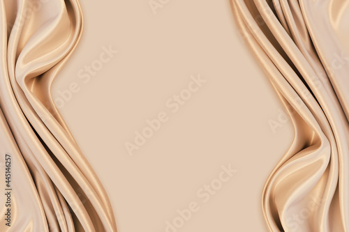 Beautiful elegant wavy light brown / beige satin silk luxury cloth fabric texture with monochrome background design. Copy space