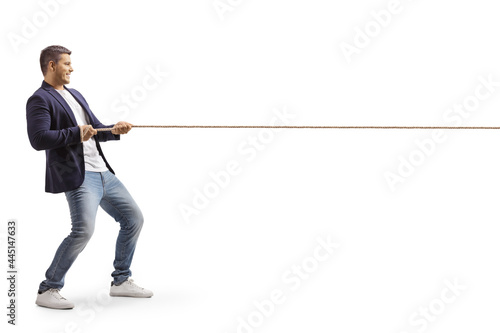 Full length profile shot of a young casual man pulling a rope photo