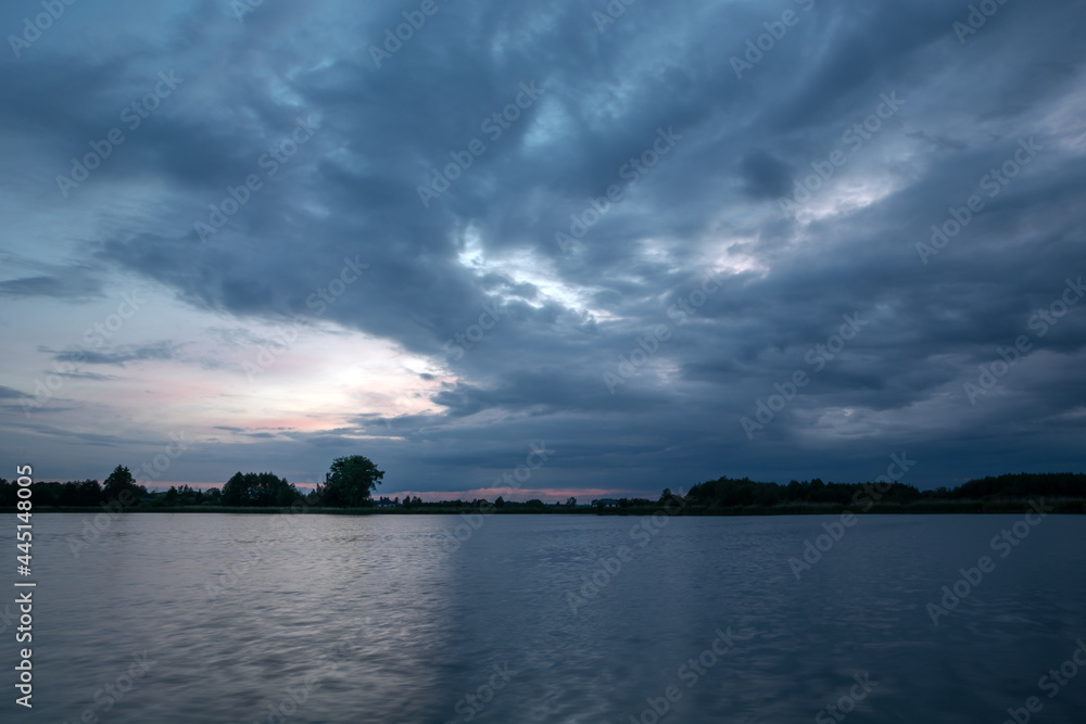 Dark evening clouds landscape over the lake
