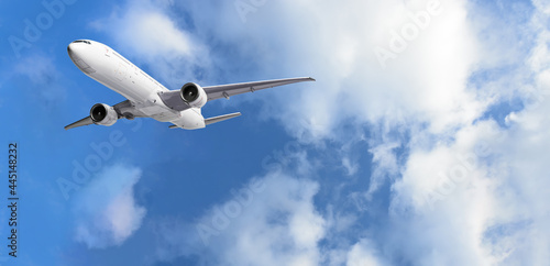 Airplane flying above clouds on blue sky background