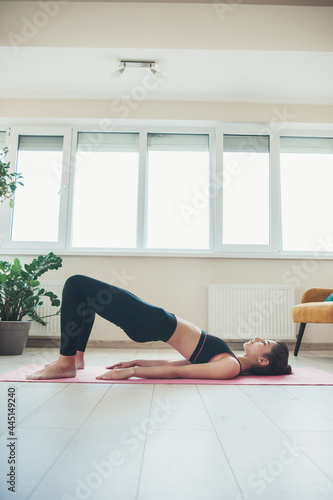Caucasian woman with brunette hair is planking on the floor during a sport session