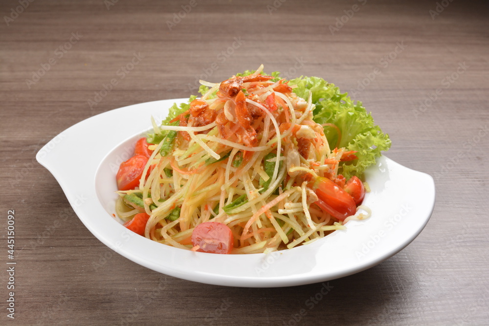 cold thai style spicy chilli sauce papaya and mango vegetable salad and shrimp in bowl on wood table asian Thai appetiser halal menu cold thai style spicy chilli sauce papaya and mango vegetable salad and shrimp in bowl on wood table asian Thai appetiser halal menu