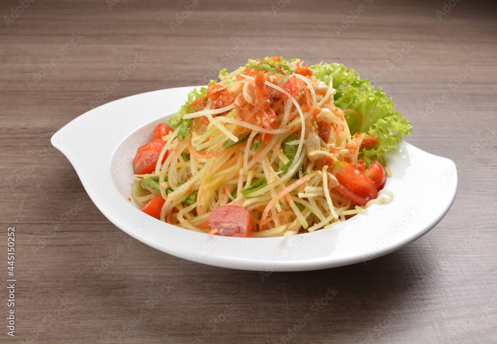 cold thai style spicy chilli sauce papaya and mango vegetable salad and shrimp in bowl on wood table asian Thai appetiser halal menu cold thai style spicy chilli sauce papaya and mango vegetable salad and shrimp in bowl on wood table asian Thai appetiser halal menu