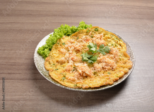 golden stir fried egg omelette with seafood and meat on wood table asian Thai appetiser halal menu