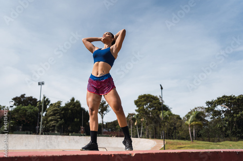 Young Latina sportswoman posing in sportswear outdoors. © René Stevens