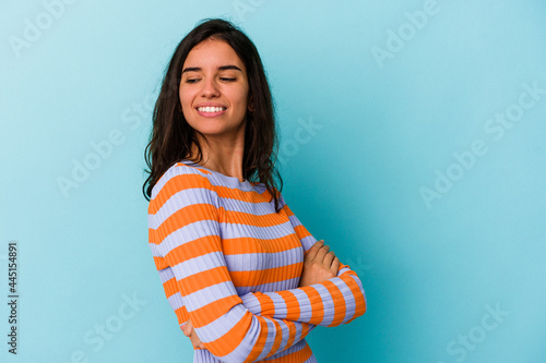 Young caucasian woman isolated on blue background smiling confident with crossed arms. © Asier