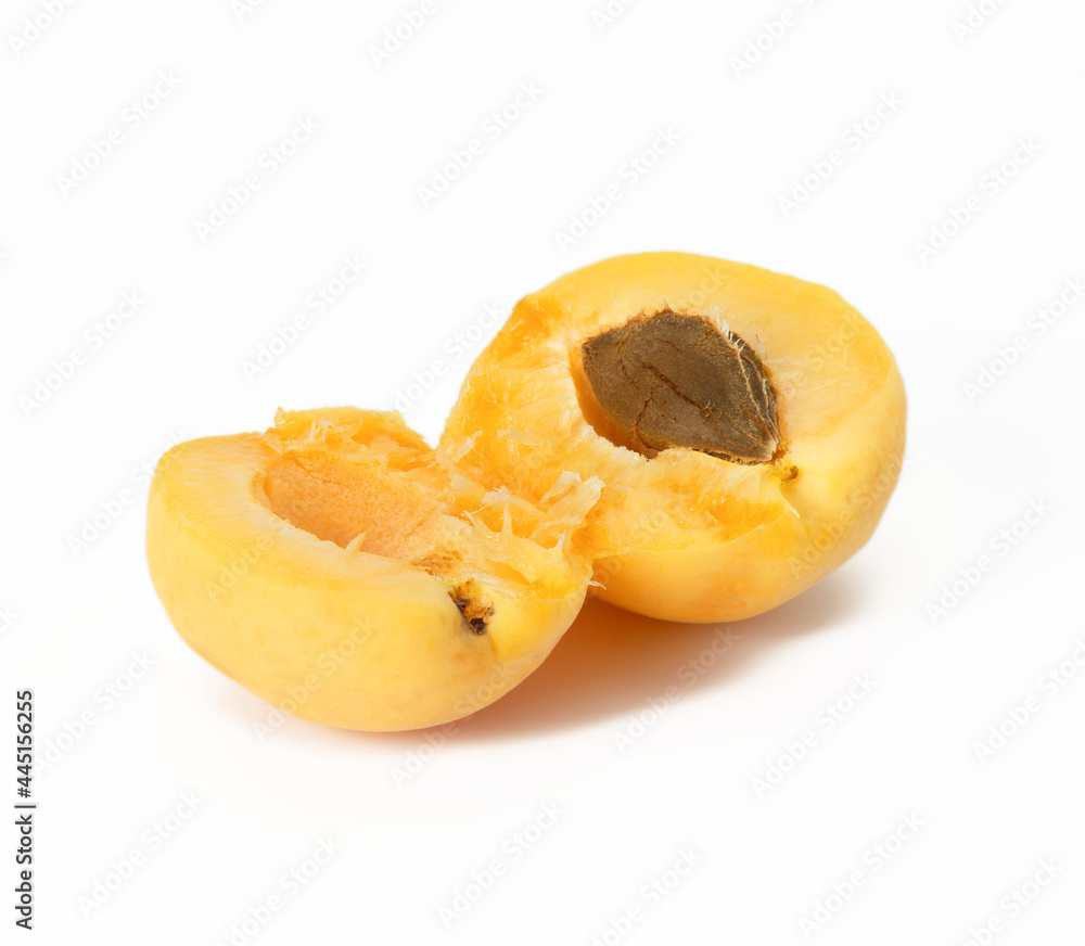 ripe yellow apricot broken in half on white background ripe yellow apricot broken in half on white background