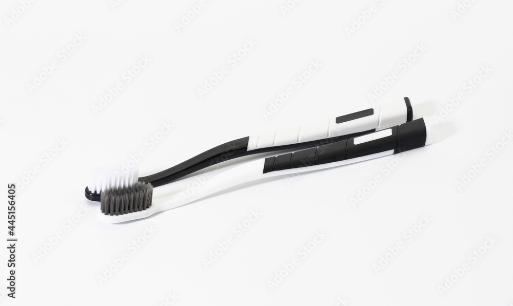 two black and white plastic toothbrushes on a white background two black and white plastic toothbrushes on a white background