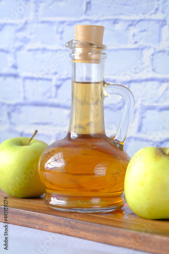 apple vinegar in glass bottle with fresh green apple on table 