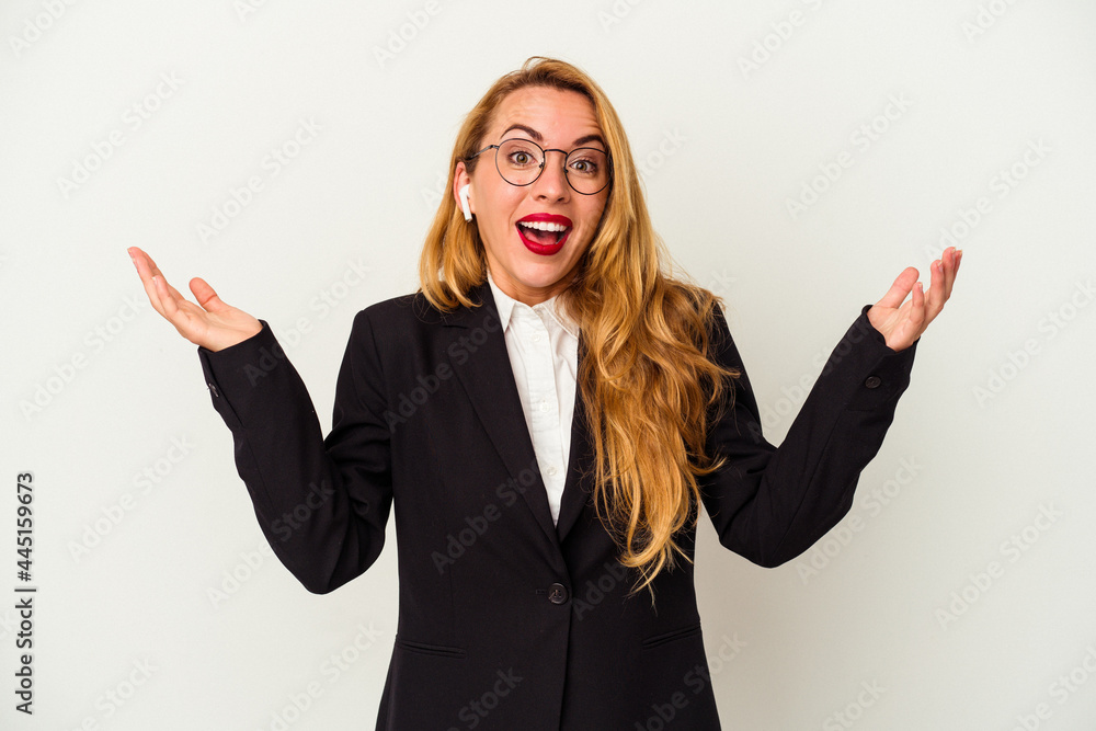 Caucasian business woman wearing a wireless headphones isolated on white background receiving a pleasant surprise, excited and raising hands. Caucasian business woman wearing a wireless headphones isolated on white background receiving a pleasant surprise, excited and raising hands.