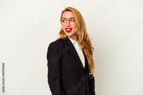 Caucasian business woman wearing a wireless headphones isolated on white background looks aside smiling, cheerful and pleasant.