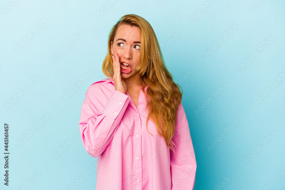 Caucasian woman isolated on blue background is saying a secret hot braking news and looking aside Caucasian woman isolated on blue background is saying a secret hot braking news and looking aside