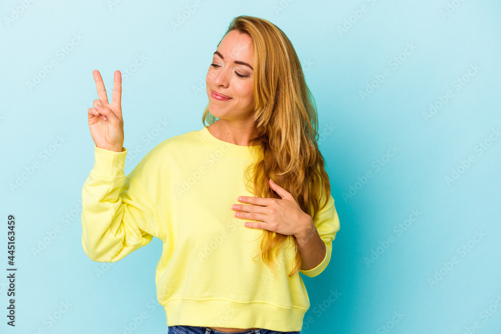 Caucasian woman isolated on blue background taking an oath, putting hand on chest. Caucasian woman isolated on blue background taking an oath, putting hand on chest.