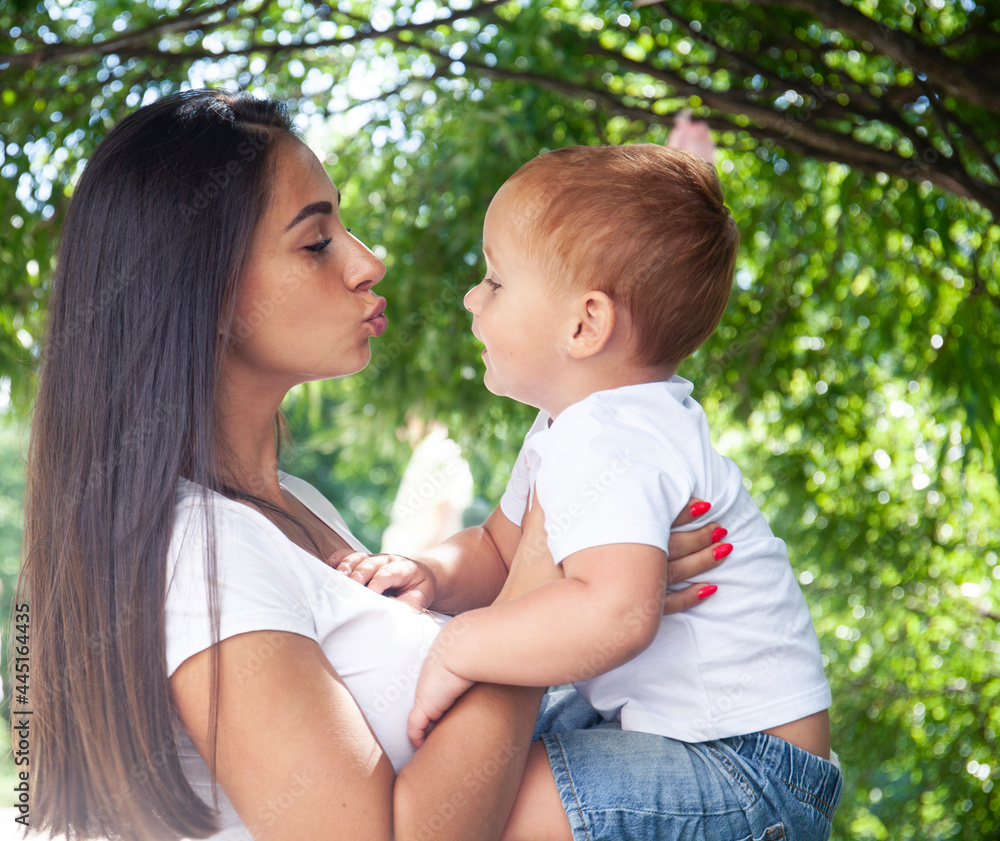 young pretty brunette mother with little cute boy walking in park happy smiling, lifestyle people concept young pretty brunette mother with little cute boy walking in park happy smiling, lifestyle people concept