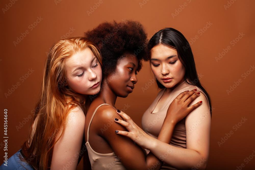 young pretty asian, caucasian, afro woman posing cheerful together on brown background, lifestyle diverse nationality people concept young pretty asian, caucasian, afro woman posing cheerful together on brown background, lifestyle diverse nationality people concept