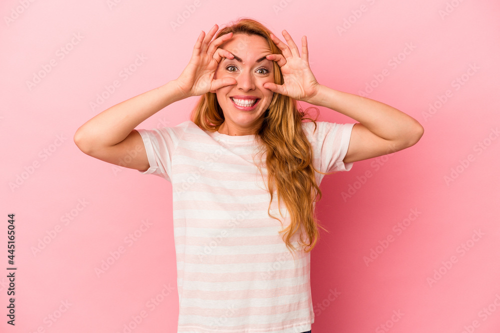 Caucasian blonde woman isolated on pink background keeping eyes opened to find a success opportunity. Caucasian blonde woman isolated on pink background keeping eyes opened to find a success opportunity.