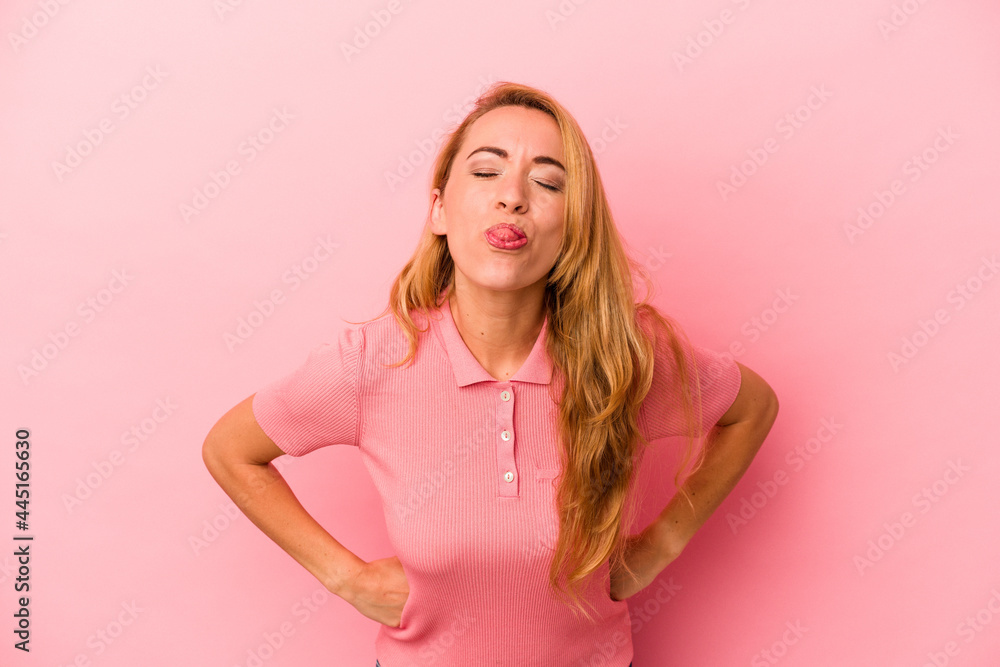 Caucasian blonde woman isolated on pink background funny and friendly sticking out tongue. Caucasian blonde woman isolated on pink background funny and friendly sticking out tongue.
