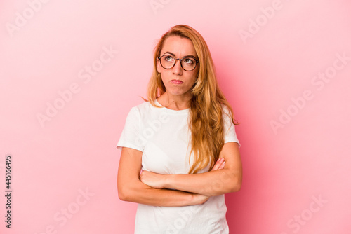Caucasian blonde woman isolated on pink background tired of a repetitive task.