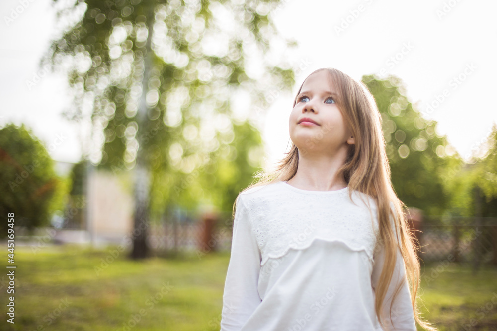 beautiful girl in a white blouse looking up in nature in sunlight beautiful girl in a white blouse looking up in nature in sunlight